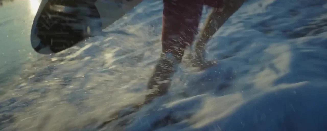 An underwater view beneath a surfboard, a contextual still from the supplied film.